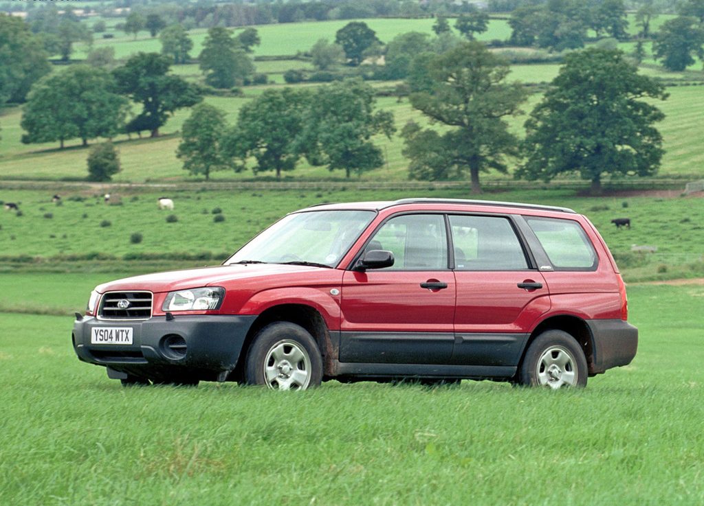 Tamsiai raudonas Subaru Forester 2003 pievoje
